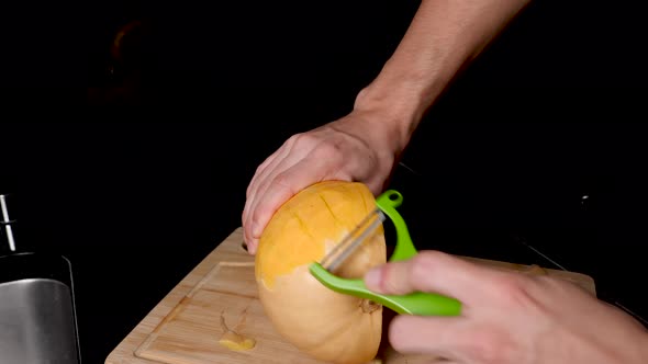 Locked Off View Of Holding Butternut Pumpkin And Peeling Skin With Vegetable Peeler