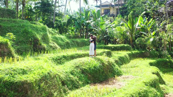 Young couple in love hugging on tranquil place of green landscape with rice terraces of agricultural