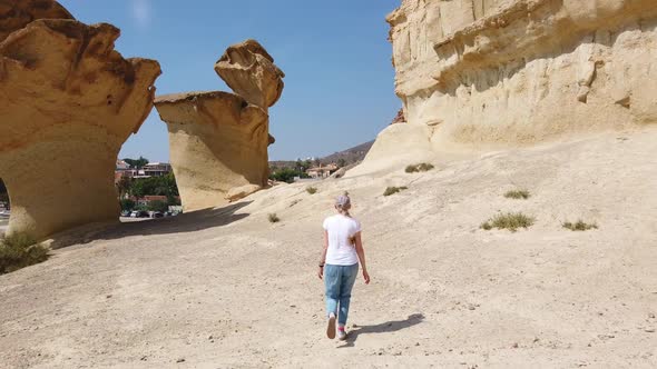 Girl Walking Through the Desert Near Yellow Futuristic Rock.