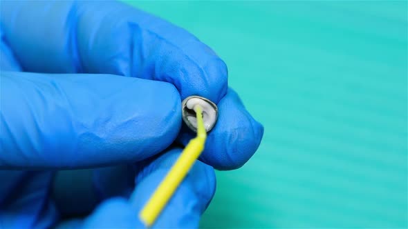 Dental Technician Apply Cement To Tooth