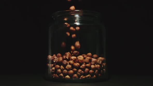 SLOW MOTION: Peeled Nuts Falling Into A Glass Jar