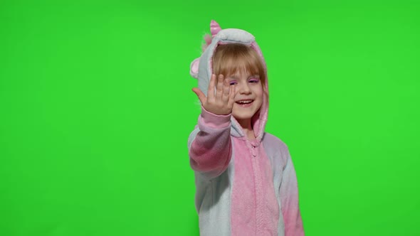 Little Child Girl Smiling Pointing at Camera Making Gun Gesture with Hands in Unicorn Pajamas