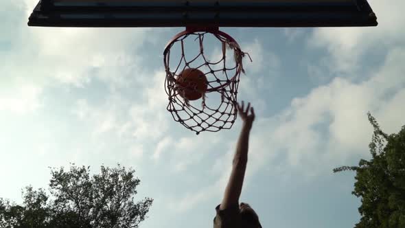 Amateur Basketball Player Hit the Basket Scores Perfect Shot in Slow Motion in Front of Cloudy Sky