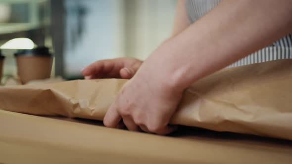 Unrecognizable woman packing a sandwich to take away. Shot with RED helium camera in 8K.