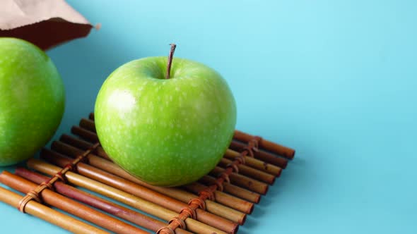 Close Up of Green Color Apple and a Paper Bag on Table