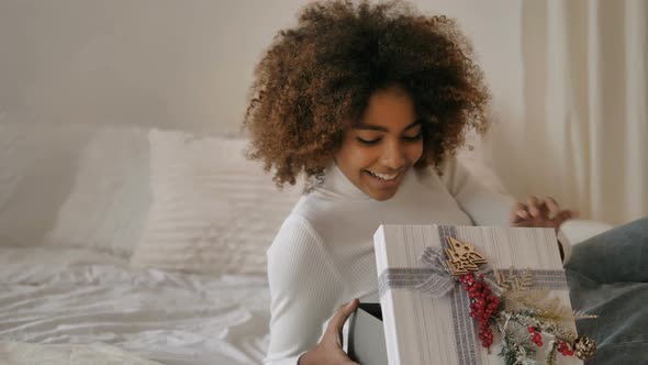 Lady Holds Present Box Against Designer White Christmas Tree