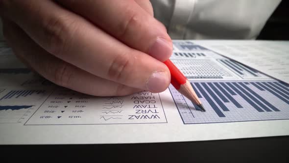 Accountant Analyzing Business Marketing Data on Paper Dashboard at Office Table