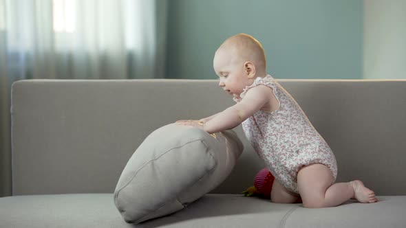 Playful Baby Girl Having Fun on Sofa at Home, Active Infant Discovering World