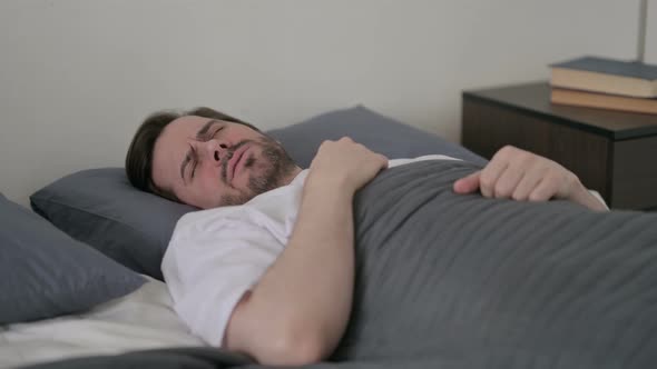 Young Man Waking Up From Nightmare in Bed