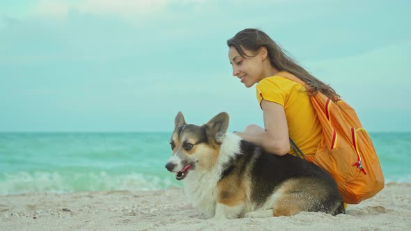 Attractive Young Woman Smiling and Spending Time Together with Her Pet Cute Corgi Dog Outdoors at