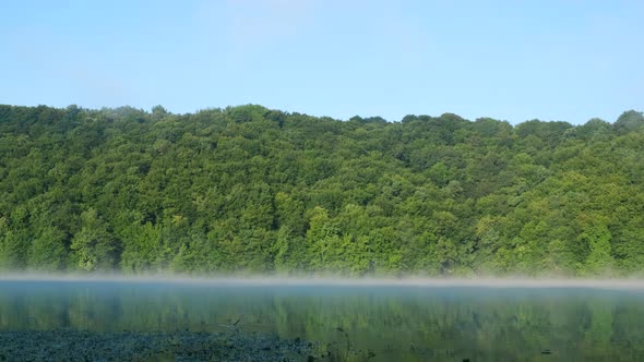 Morning fog over a calm lake. View from a slow floating pair.