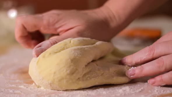 Baker is kneading and folding yeast dough