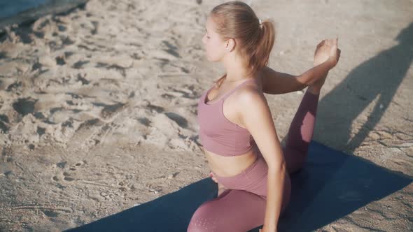 Woman Does Yoga Exercises Stretches at Morning with View on Ocean Slow Motion