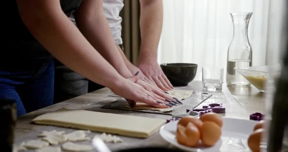 Young Couple Making Cookies in a Kitchen Using Sheets of Ready Made Dough or Pastry To Cut Out the