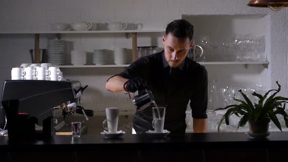 Skillful Barista Filling Coffee Glass with Milk