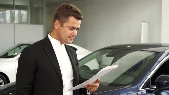 A Satisfied Buyer Reads the Documents of the Car