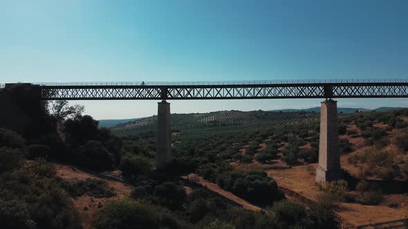 Aerial view cyclist on metal bridge in andalucia Cabra Santo Cristo sunny day