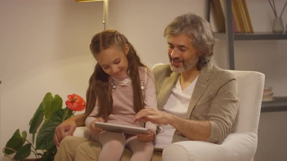 Grandfather Sitting With Little Girl