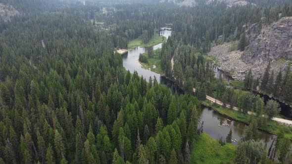 Overhead drone shot of the winding Payette River in the Idaho wilderness as people kayak. This 4K ci