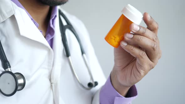 Doctor Holding Medical Pill Container Reading Something