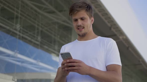 Handsome Young Man Sms Texting Using App on Smartphone