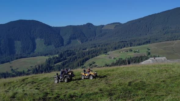 Tourists Riding Quad Bikes on Mountains Forests Background