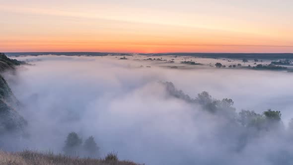 Timelapse Mist Curling Over River and Meadow on Sunrise Background