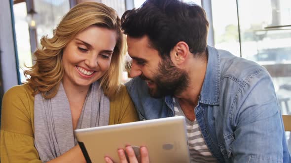 Couple using digital tablet in caf������������