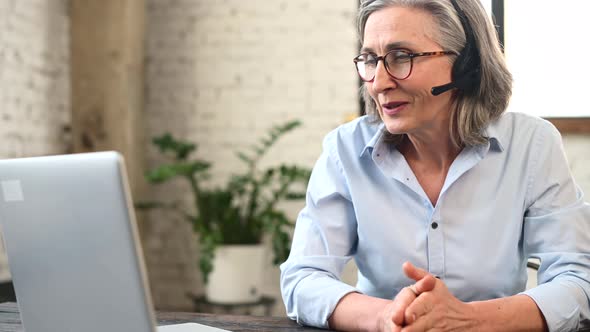 Senior Female Office Worker Wearing a Headset