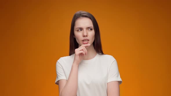 Young Woman Thinking About Her Problem Came Up with the Idea Against Yellow Background