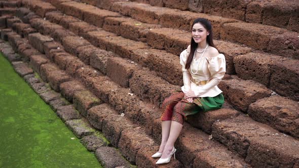 slow motion of happy beautiful woman in Thai traditional dress near the pond
