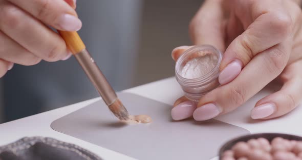 Close Up of Make Up Artist Mixing Concealer and Highlighter To Find Right Skin Shade