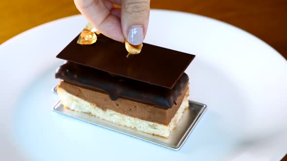 Chef Woman Hand Place a Hazelnut on Opera Cake Desserts in Restaurant