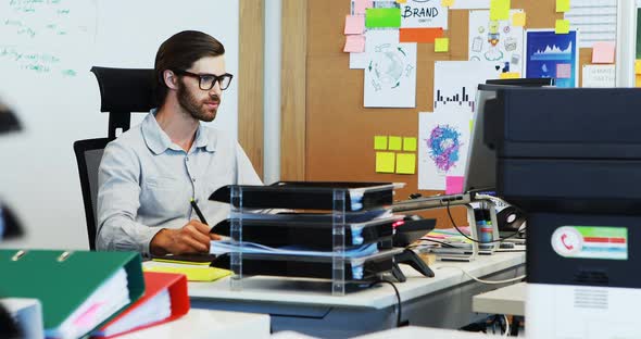 Male graphic designer working on graphic tablet at desk