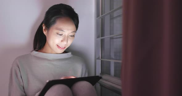 Woman use of tablet computer at night