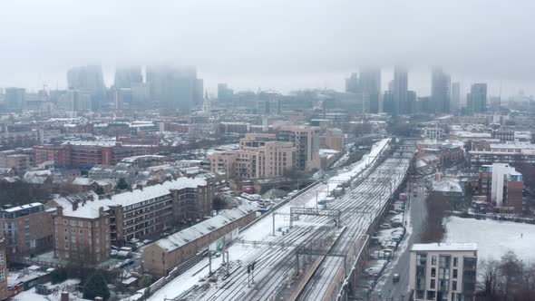 stable aerial drone shot of Snow covering Central London and train tracks