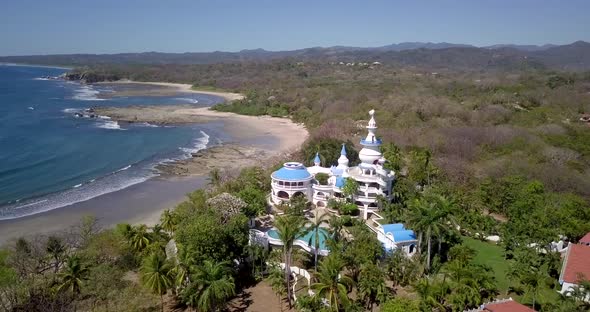 Aerial drone view of the beach, rocks and tide pools in Guiones, Nosara, Costa Rica.