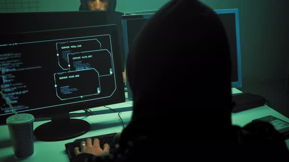 Male Hacker Working on a Computer in a Dark Office Room.  (UHD)