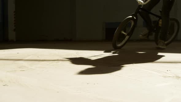 BMX rider in an empty warehouse