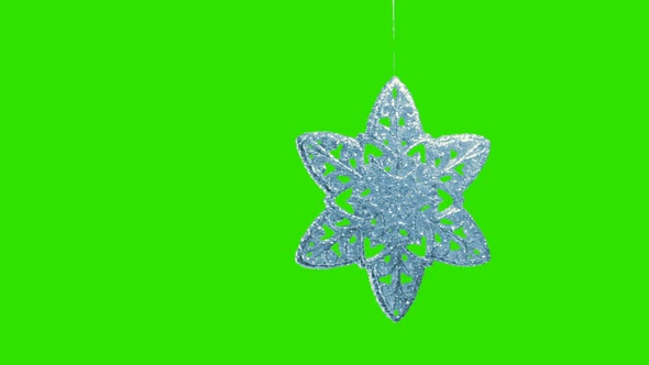 Ornament in the Form of a Snowflake on a Green Background