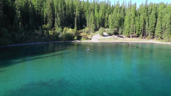 Isolated View Of A Man Stand-Up Paddling In Blue Calm Water At ashley lake in montana, United States