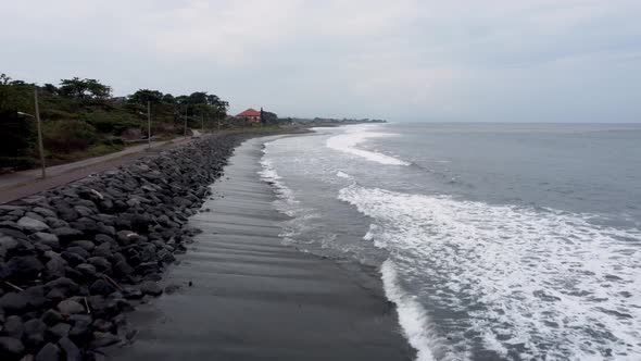 Drone flying along the black sand beach