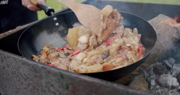 Close Up of Fresh Vegetables Cooked in a Pan Over an Open Fire. Slow Motion