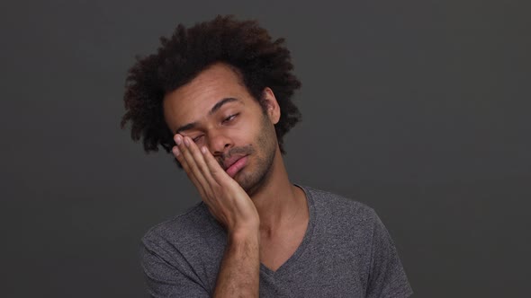 Dark Skinned Young Man with Afro Haircut Trying to Wake Himself Up Slapping on His Cheek Isolated