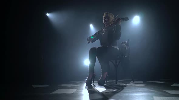 Woman Plays the Composition on the Violin on the Floor Are Scattered Sheets with Notes