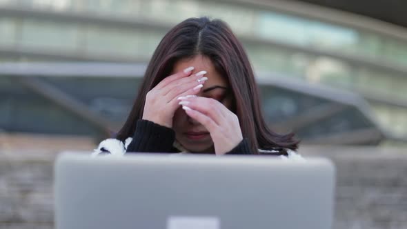 Tired Beautiful Brunette Looking at Laptop and Rubbing Face