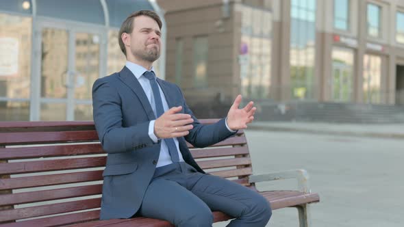 Tense Businessman Feeling Frustrated while Sitting Outdoor on Bench