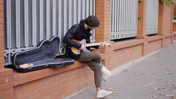 Guy Playing on the Giutar on the Street