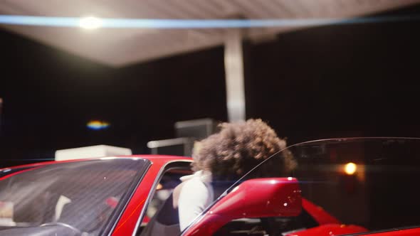 Woman With Afro Hair Exiting Red Ferrari 348 TB In Gas Station