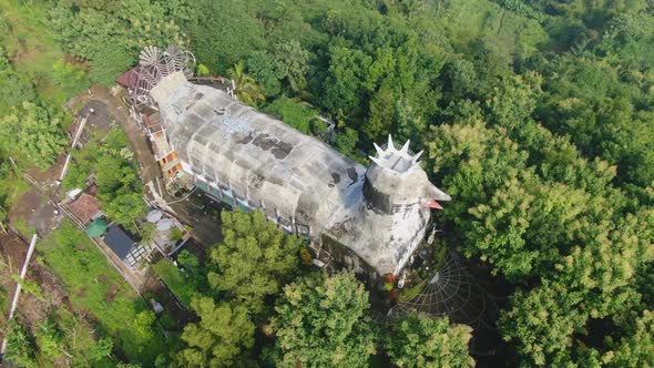 Aerial tilt up view of Chicken Church to reveal evergreen tropical forest, Java